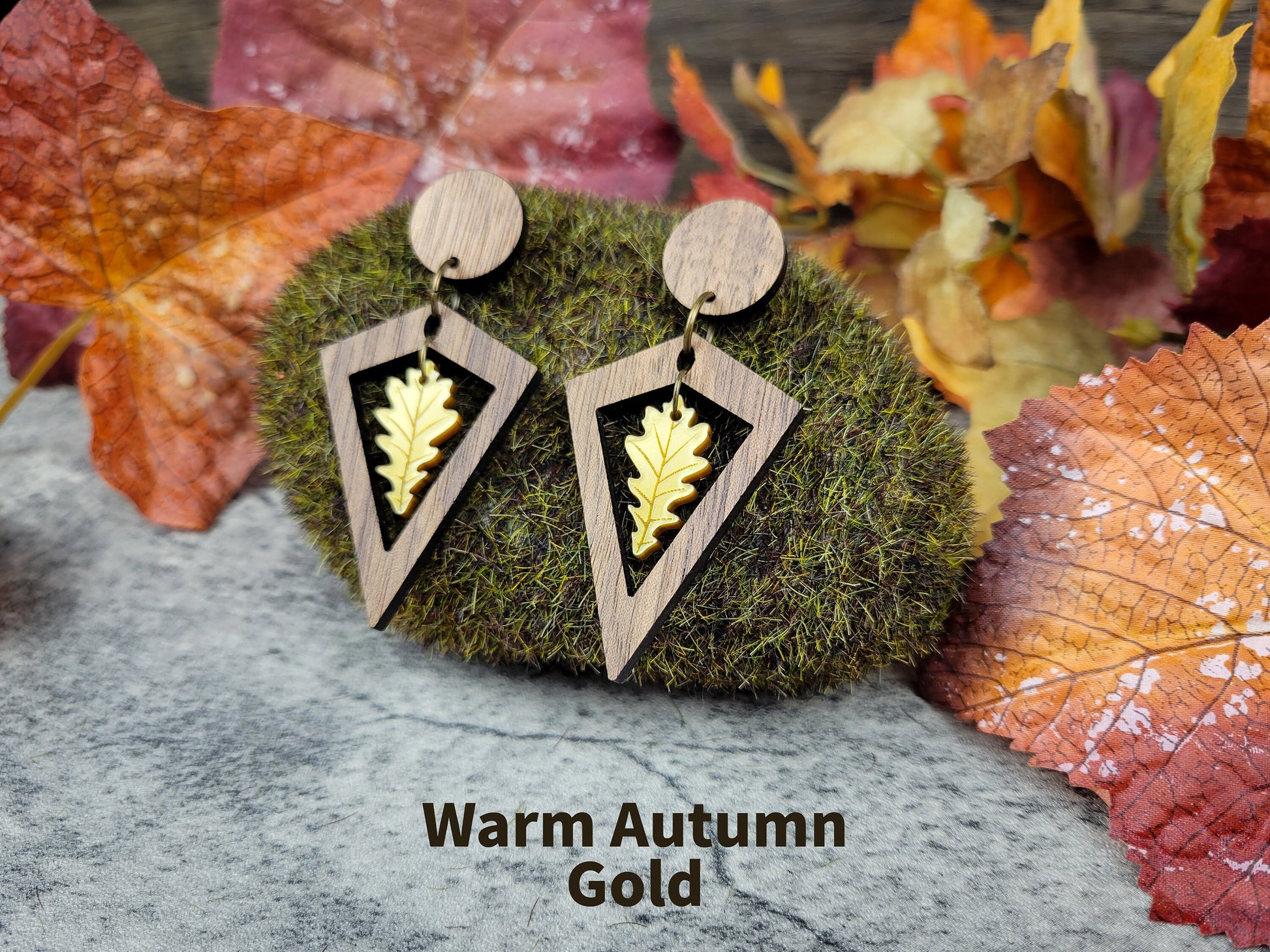 Diamond-shaped walnut wood earrings with metallic acrylic oak leaf dangle in fall colors - autumn gold angled view