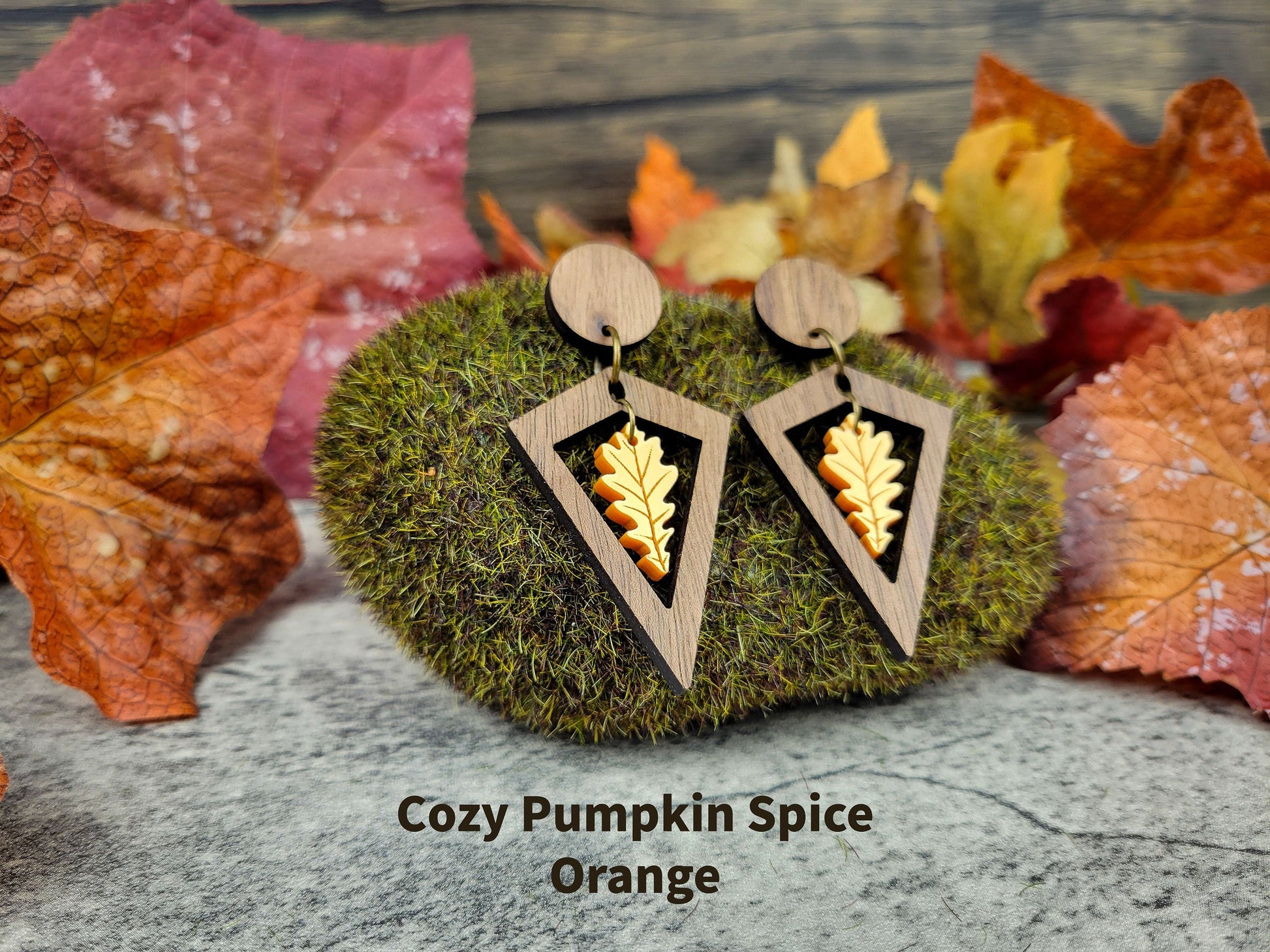 Diamond-shaped walnut wood earrings with metallic acrylic oak leaf dangle in fall colors - pumpkin spice angled view