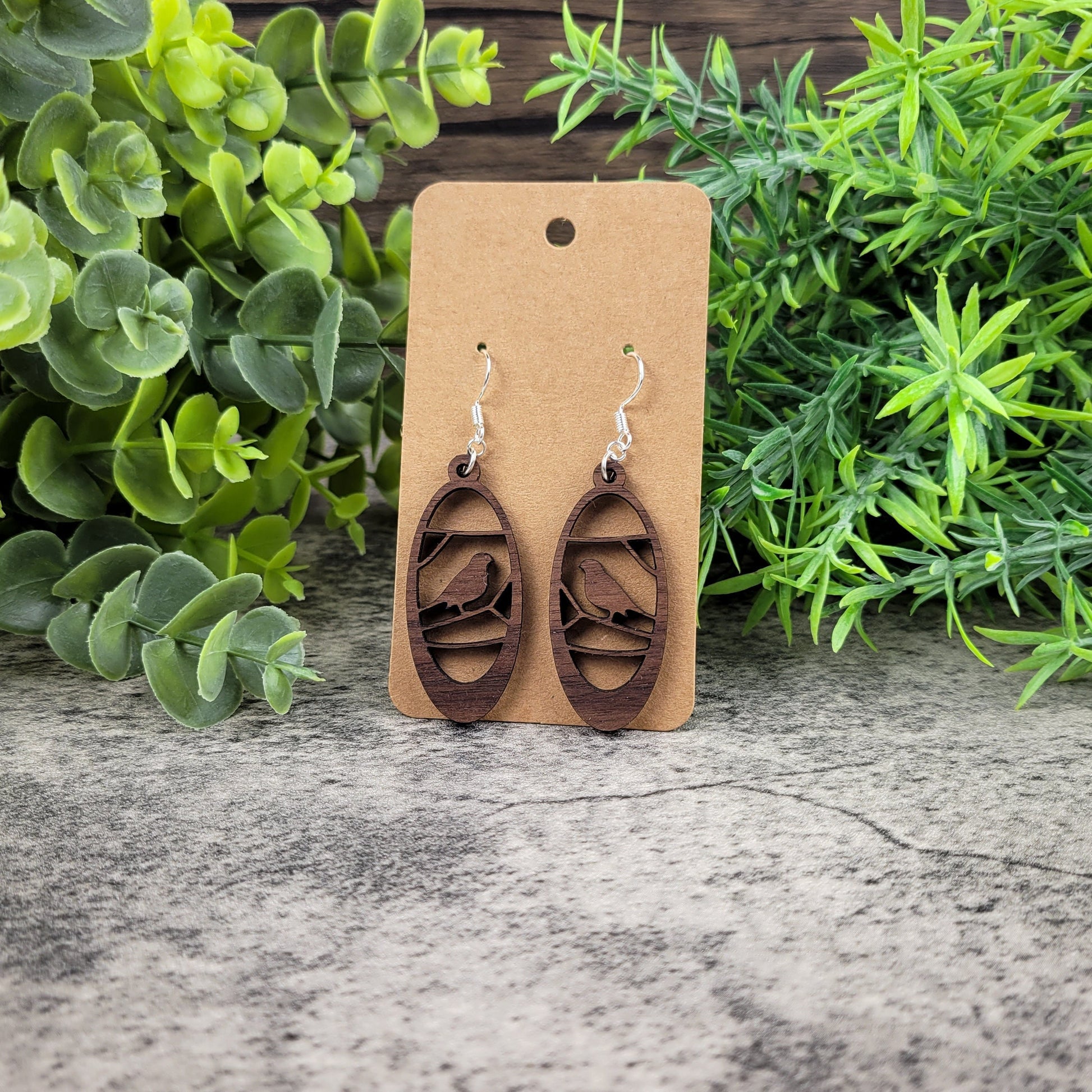 Lightweight walnut wood earrings featuring a bird in branches design on hypoallergenic sterling silver-plated ear wires - front view