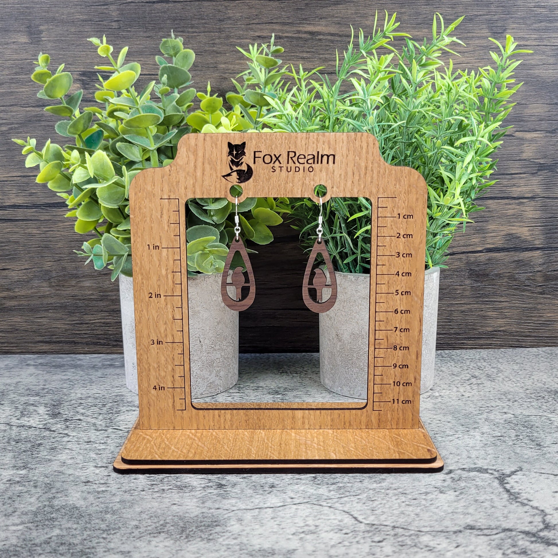 Lightweight walnut wood earrings with bird silhouette design on sterling silver-plated ear wires – hanging on size display