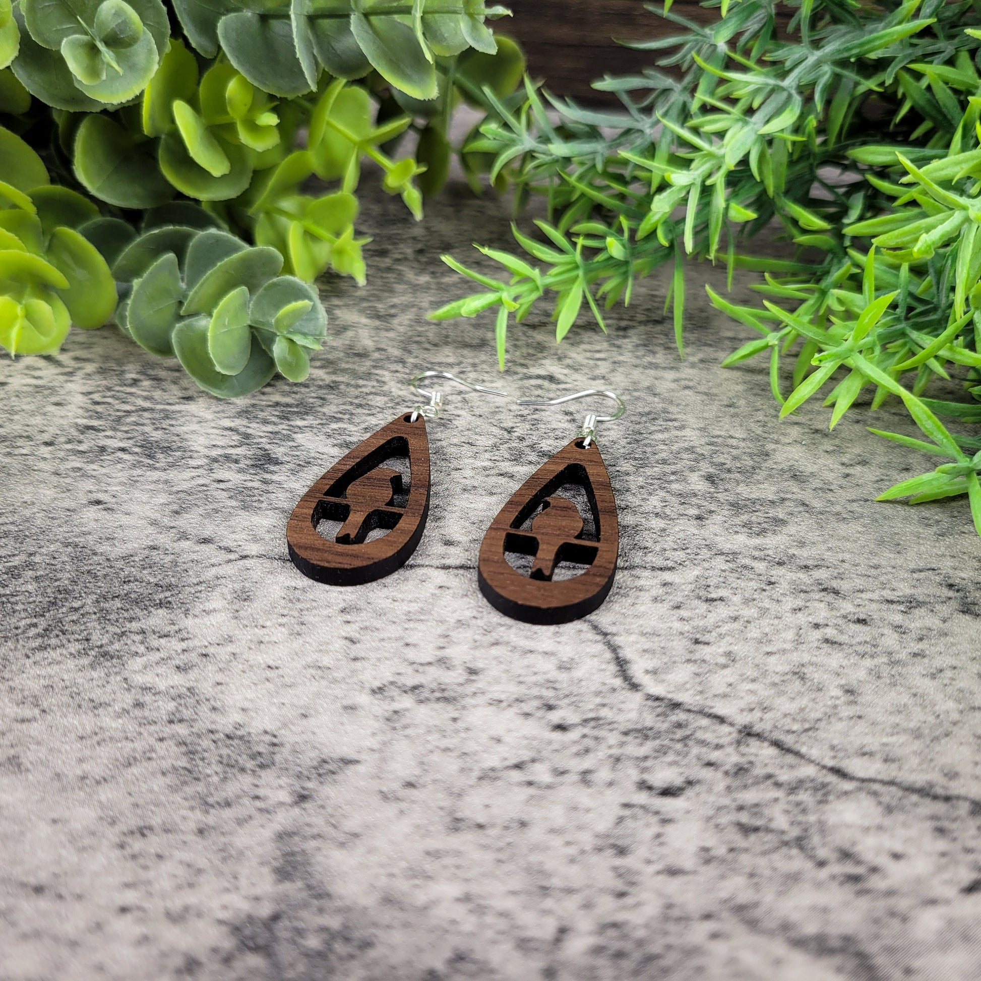 Lightweight walnut wood earrings with bird silhouette design on sterling silver-plated ear wires – left angle view