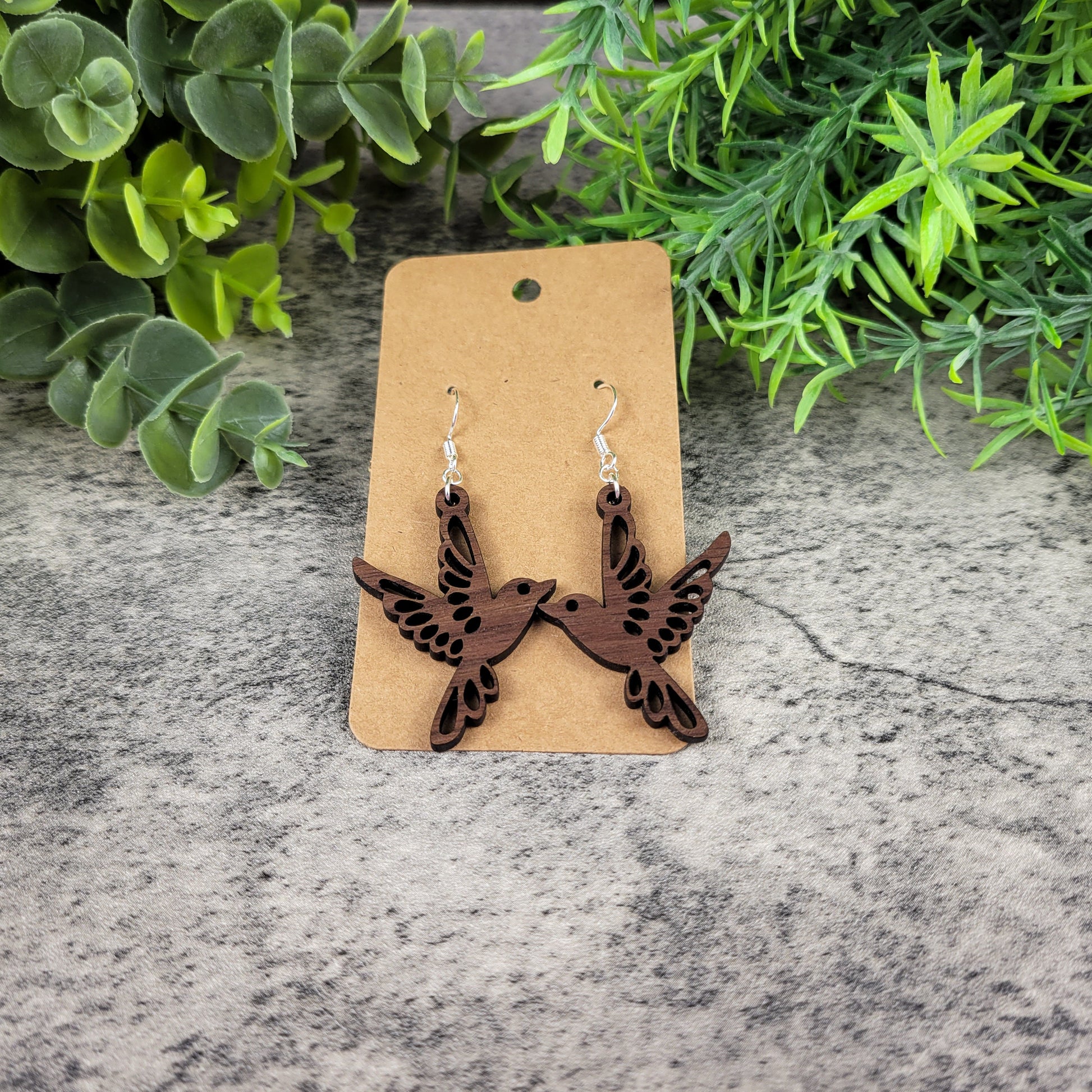 Lightweight walnut wood bird earrings featuring birds in flight design with sterling silver-plated ear wires - angled front view