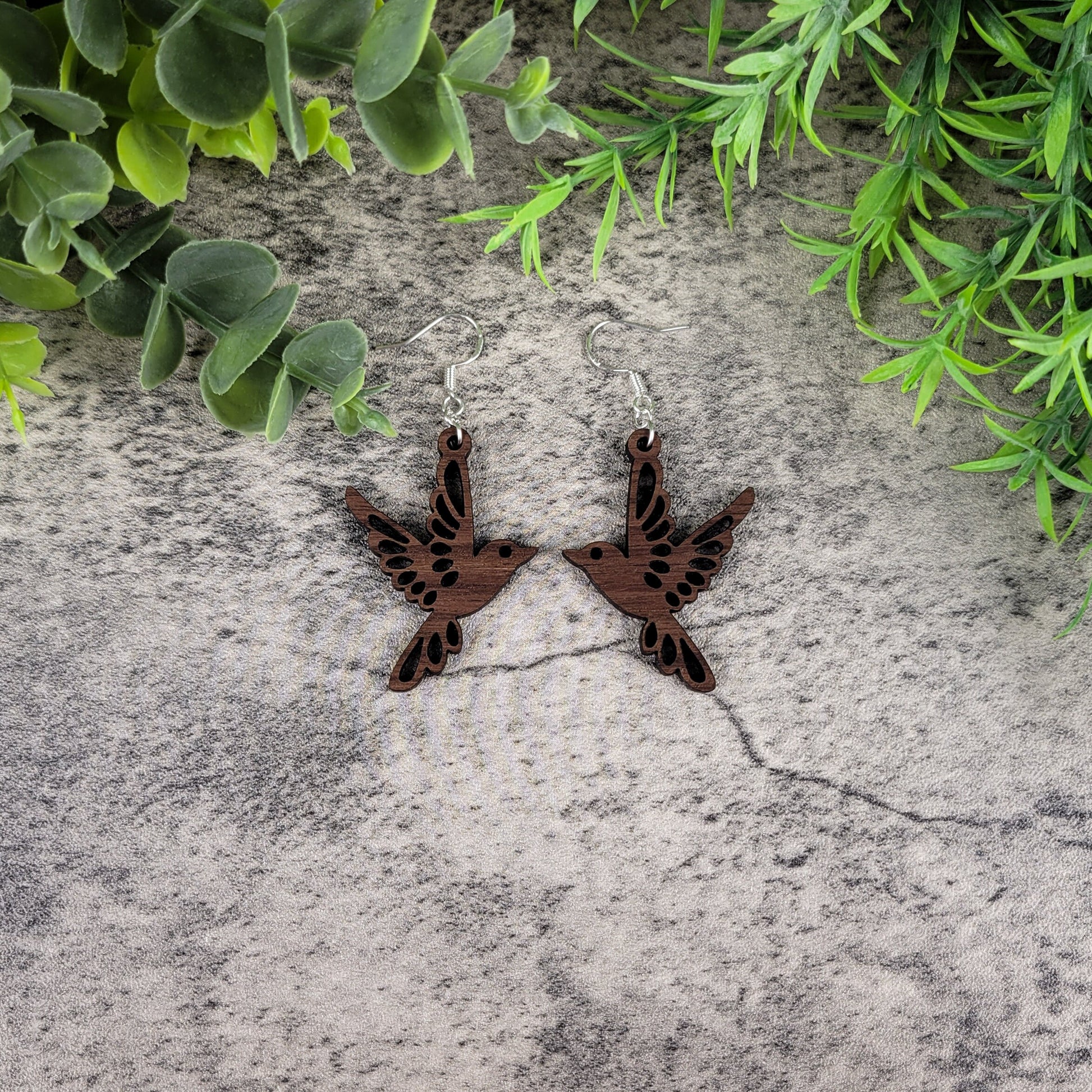 Lightweight walnut wood bird earrings featuring birds in flight design with sterling silver-plated ear wires - flat front view