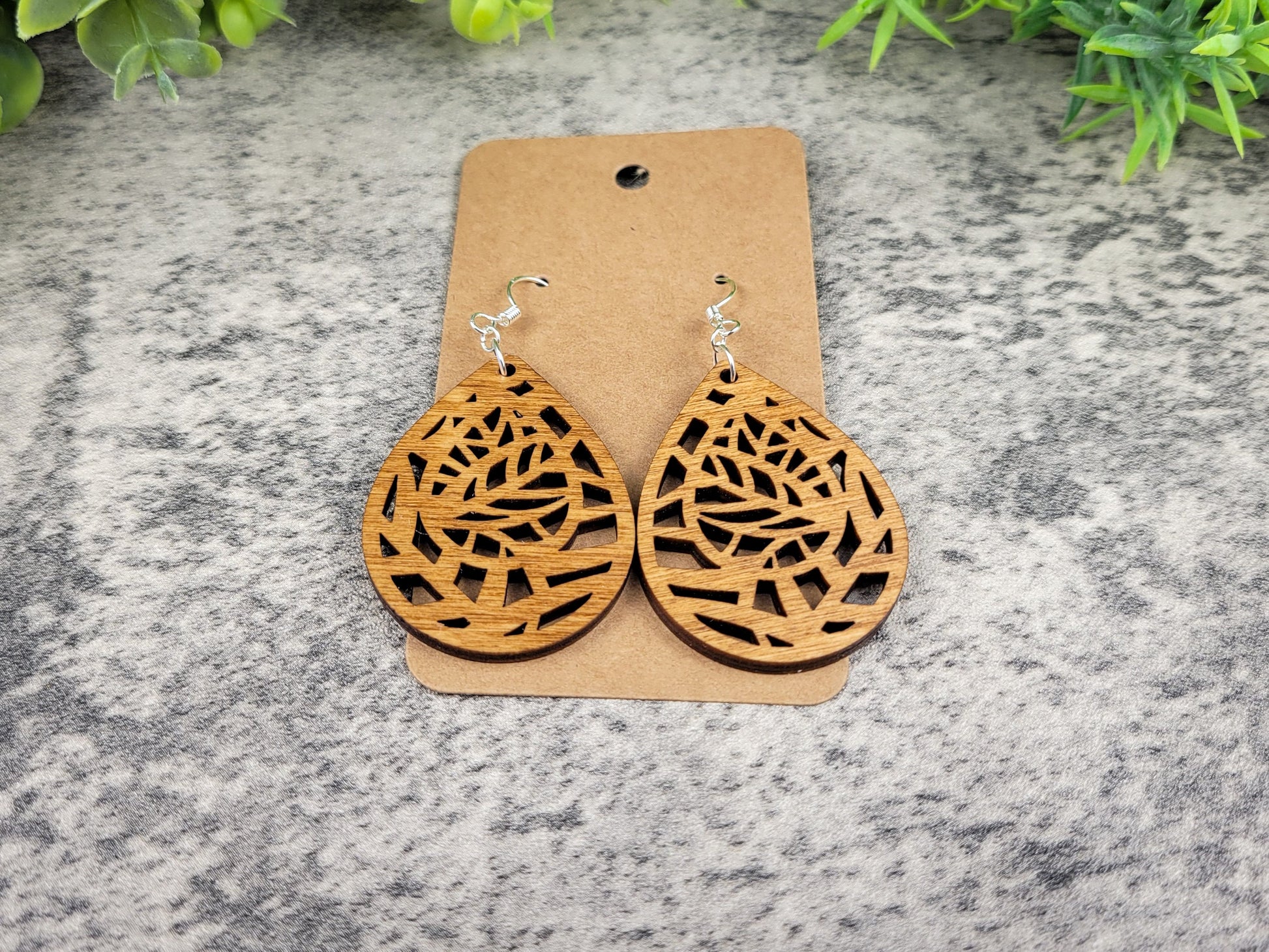 Lightweight botanical teardrop earrings made of laser-cut birch wood with sterling silver-plated hooks – flat view