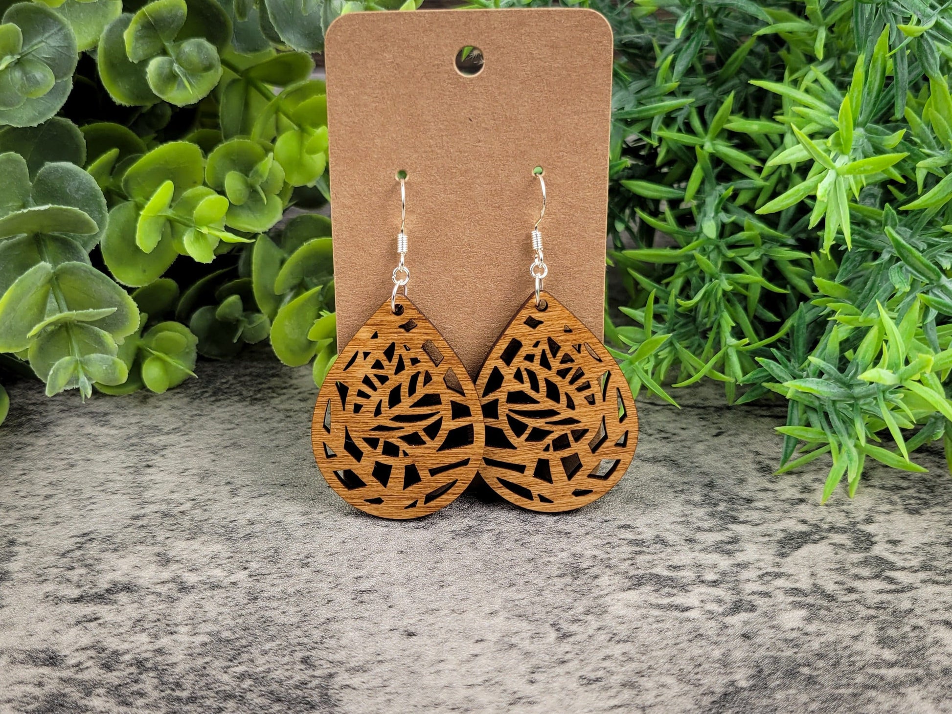 Lightweight botanical teardrop earrings made of laser-cut birch wood with sterling silver-plated hooks – front view