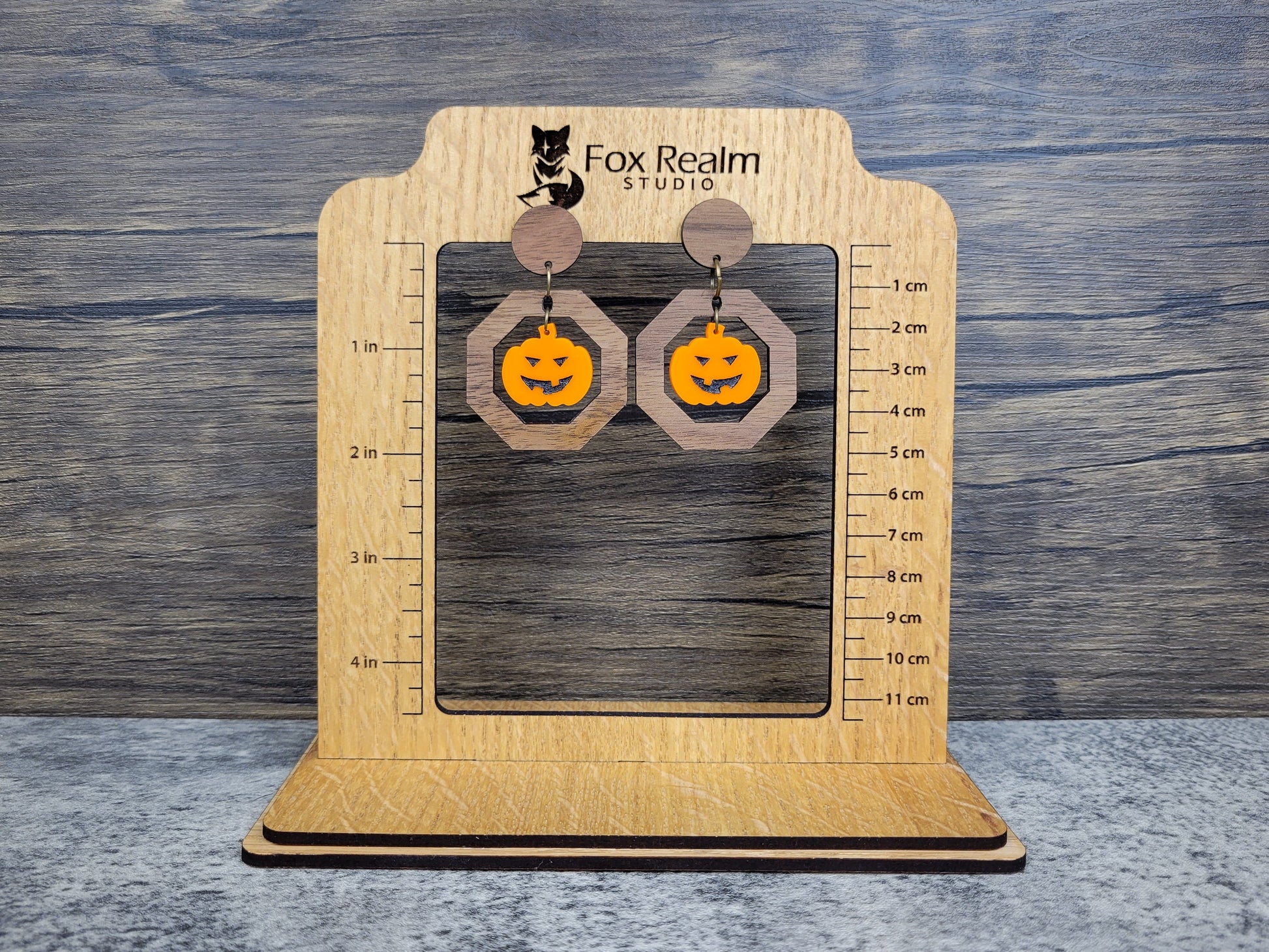 Wooden earring size display with, showing earrings with pumpkin designs.