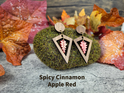 Diamond-shaped walnut wood earrings with metallic acrylic oak leaf dangle in fall colors - apple red angled view