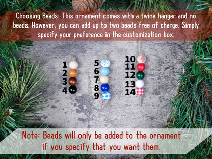 Customization options for a Christmas ornament with beads on a textured surface surrounded by greenery.